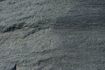 Natural stone of grey color with a chipped uneven texture background