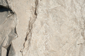 Natural stone with cracks of brown color with a chipped uneven texture background