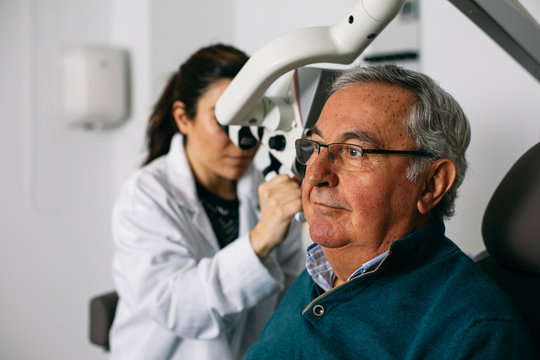 ENT physician examining ear of a senior man