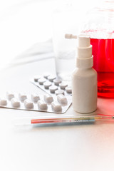 Pills, thermometer, antibacterial spray, liquid soap on white background. Flu prevention and treatment.