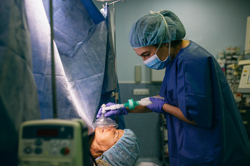 Doctor putting anesthesia mask to patient in operating room