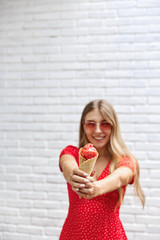 Summer, beauty and vacation concept. Vertical shot of happy attractive blond woman enjoying sunny day outdoors, extend hands with ice cream and smiling broadly, express rejoice and joy