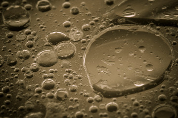Macro shots cooking oil mixed with water on the glass surface 