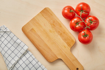 Tomatoes with on a wooden cutting board. Vegetable background. Healthy eating.