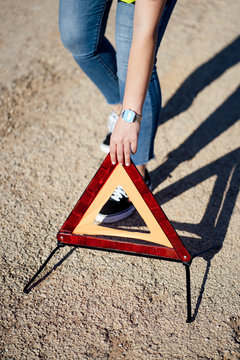 Close-up of woman posting warning triangle