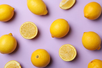 Flat lay with lemons on violet background. Fresh fruit