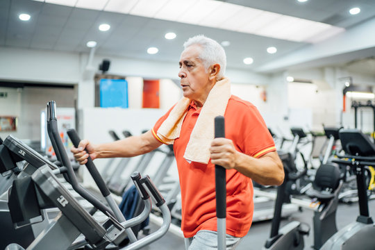 Senior man practising at stepper in gym
