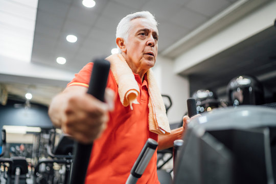 Senior man practising at stepper in gym