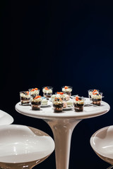 Desserts with whipped cream and strawberries on a white table. Glamorous style