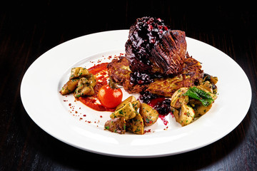 A white plate topped with steak filet mignon and vegetables