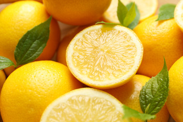 Obraz na płótnie Canvas Lemons with leaves on whole background, close up. Ripe fruit