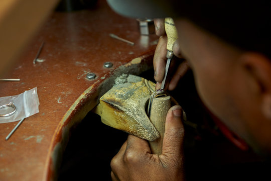 Man repairing a ring with a missing diamond