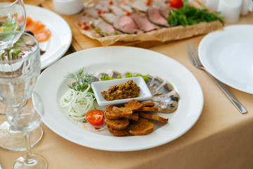 herring served in a restaurant on a white plate,
