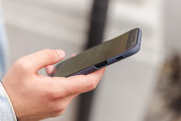 man holding a phone. mobile phone in a man's hand. checking a phone. sending messages. man reading news on a smartphone