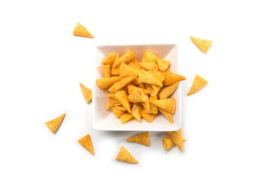 Closeup of bugles salted appetizers in a white bowl on top view on white background