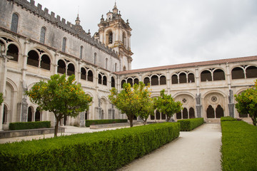 Fototapeta premium Alcobaça, Portugal: Blick in den Innenhof und den Kreuzgang des berühmten Klosters Mosteiro de Santa Maria mit den Galerien und Doppelbogen 