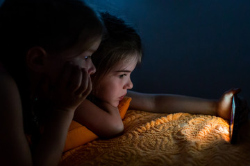 children play games on the smartphone and watch cartoons at night, child addiction