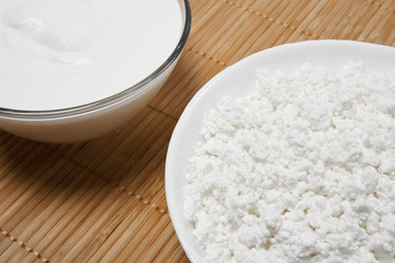 still life background with fragments of bowls with cottage cheese and sour cream on the table