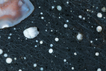 Close-up texture of black basalt with gas bubbles filled with chalcedony and zeolites structure, also known as mandelstein