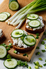sandwiches with cottage cheese and slices of cucumber on a cutting board