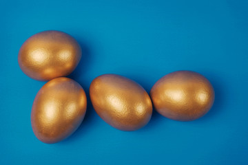 Golden eggs on a blue surface