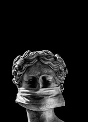 the head of a Greek statue in a protective mask with a sad look