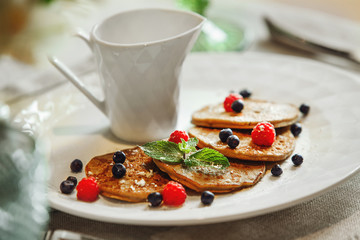 A close up of a plate of pancakes and a cup of coffee
