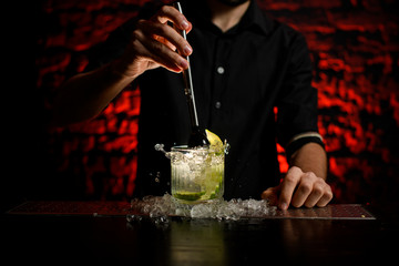 close-up barman gently mix cocktail using metal madler