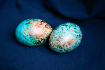 two marble Easter eggs on a dark background
