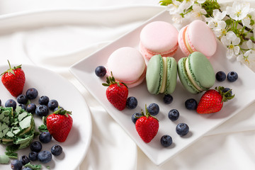 Macaroon pink and mint delicious with blueberries and strawberries and tea