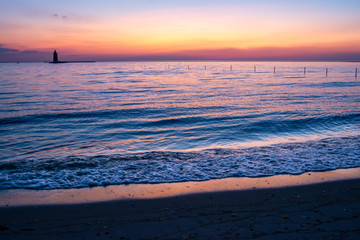 Sunset view with Delaware Breakwater Lighthouse in distance over bay 1