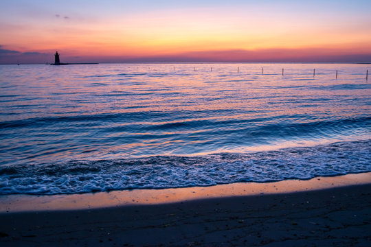 Sunset View With Delaware Breakwater Lighthouse In Distance Over Bay 1