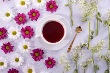 cup of coffee and buds of chrysanthemums on a white plate