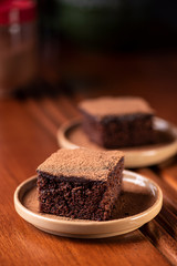Two pieces of chocolate cake on a table 