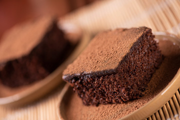 Two pieces of chocolate cake on a table 