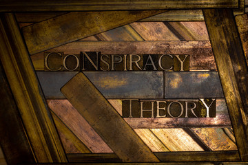 Photo of real authentic typeset letters forming Conspiracy Theory  text on vintage textured grunge copper background