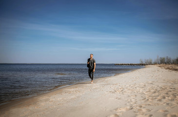 Young guy with a backpack on a sandy wild beach