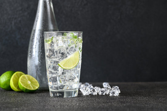 Glass Of Sparkling Water With Ice Cubes And Slice Of Lime
