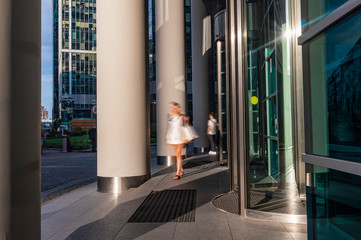  The flow of people passing through the rotating door of the modern office building ,