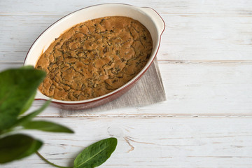 Sweet homemade sorrel pie and green Rumex leaves on a white wooden background. Original simple sweet pastries. Dessert.