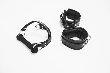 Obraz premium Leather gag and cuffs isolated on a white background