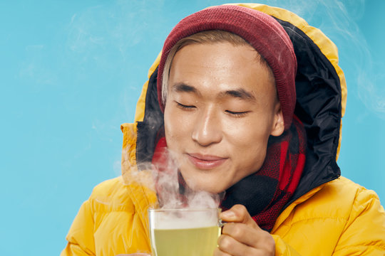 A Man Of Asian Appearance Smile Studio Gold Jacket Warming Drink