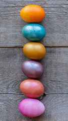 Fototapeta na wymiar Beautiful multi-colored Easter eggs lie on a old wooden background, Easter holiday, copy space