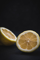 Two halfs of a lemon on black background with copy space