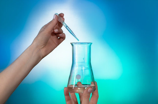 Laboratory analysis - testing of a chemical reagent in a graduated cylinder on blue background