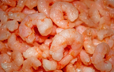 Background of peeled shrimp. Shrimp meat for sale. Texture. Seamless pattern, copy space.