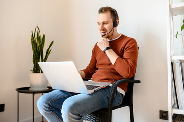 Guy uses headsets and laptops to work at home