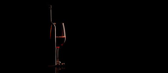 Elegant red wine glass and a wine bottle over black background - Powered by Adobe