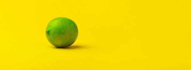 fresh green lime fruit on a yellow background