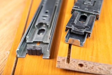 Metal sliding strips for furniture drawers. Accessories and furniture fittings in the workshop.